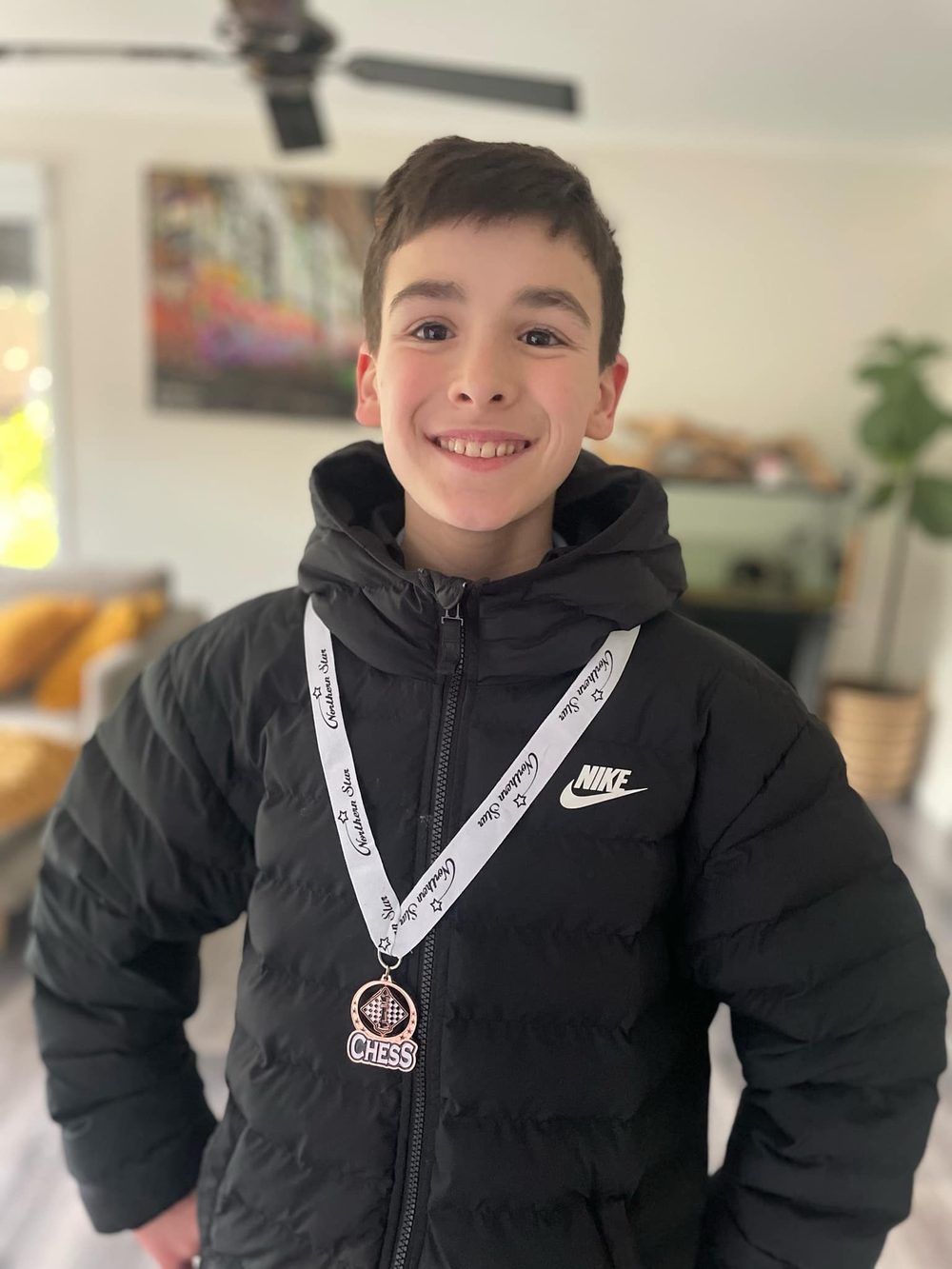 A proud Oz Chess Kids student wearing a chess medal