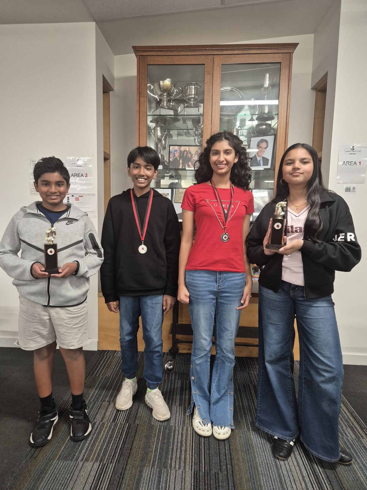 Four Oz Chess Kids students holding trophies and medals