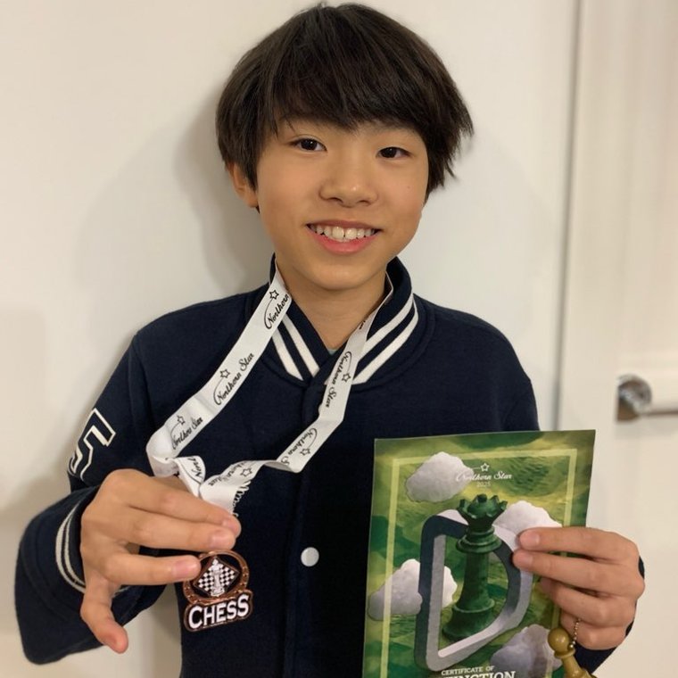 An Oz Chess Kids student with a chess medal and Certificate of Distinction